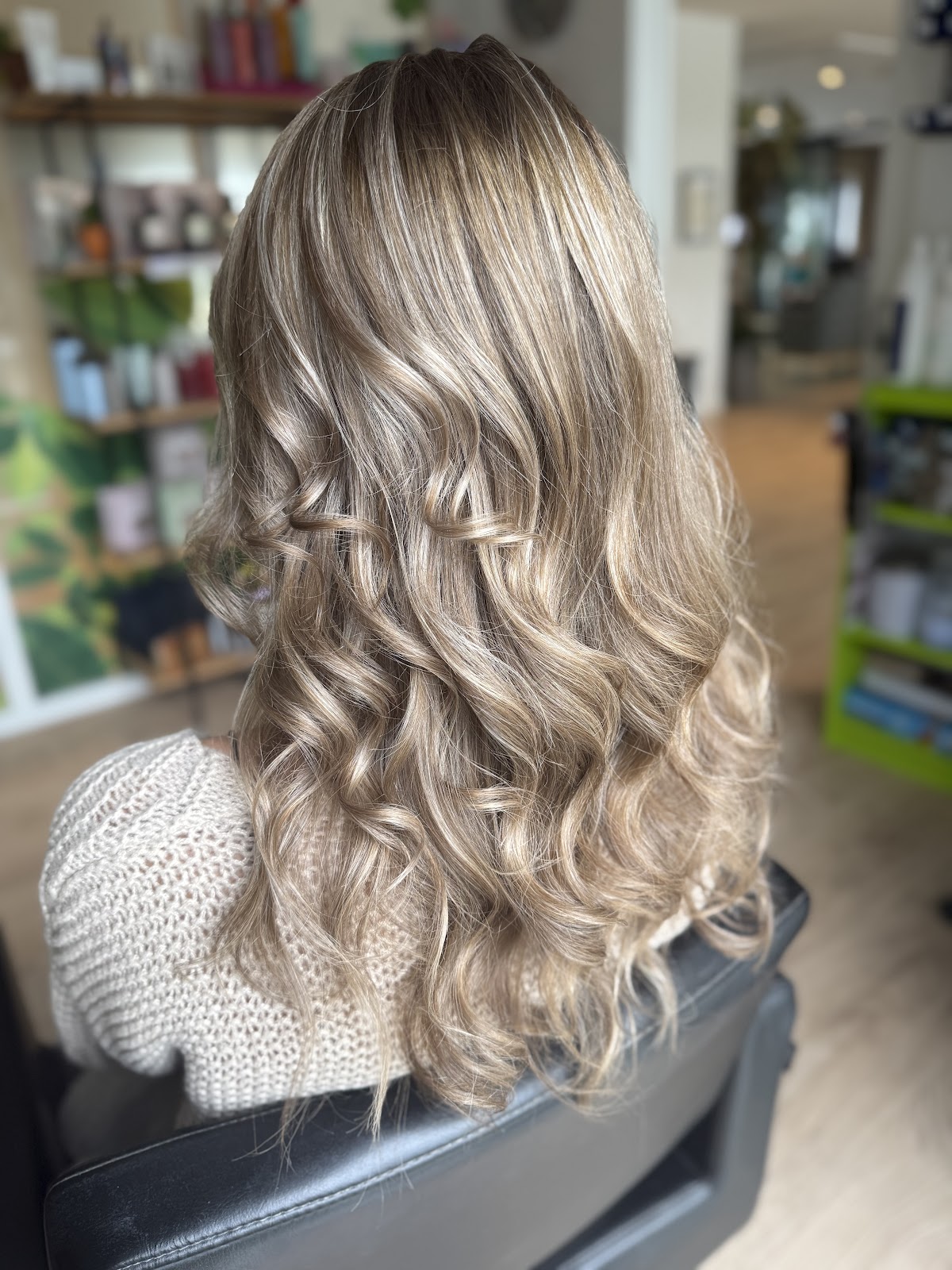 Soft blonde balayage styled into loose curls by Soleil Hair Studio